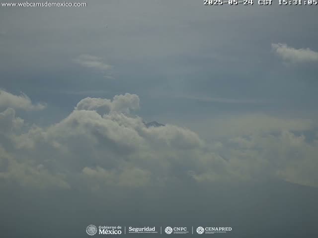 A partly cloudy sky is visible, with a mountain peak barely seen in the distance.