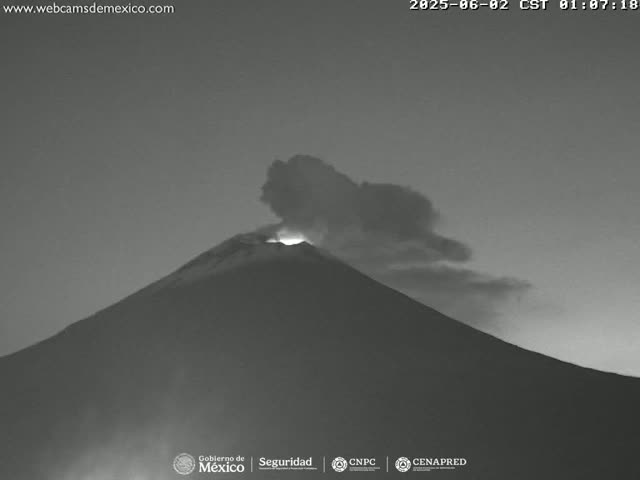 A grayscale image shows a volcano erupting under a dark, possibly twilight sky.