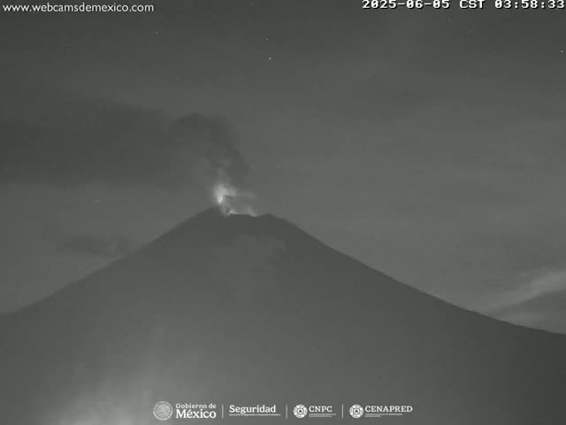 A volcano erupts at night under a dark, clear sky.