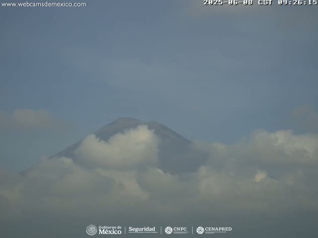 A partially cloudy sky obscures a mountain peak.