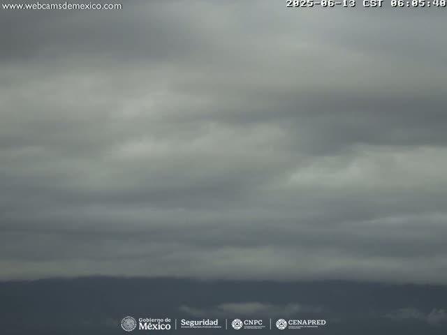 A mostly cloudy sky hangs over a distant, dark mountain range.