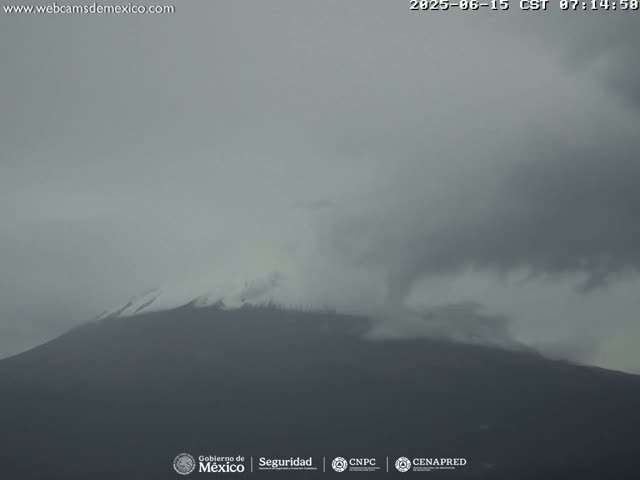 A snow-capped mountain is partially obscured by an overcast sky.