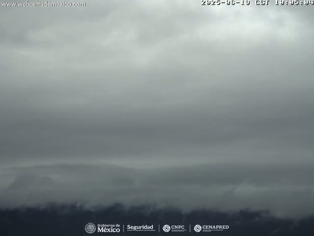 A mostly cloudy, overcast sky obscures distant, dark mountains or hills.