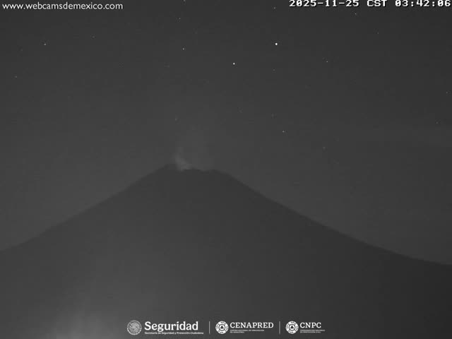 A large volcano emits a plume of smoke or ash against a clear, star-filled night sky.