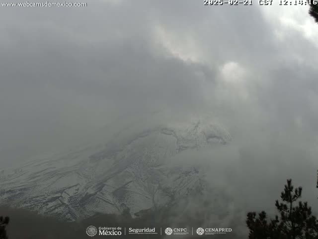 A snow-capped mountain is partially obscured by heavy fog or clouds.