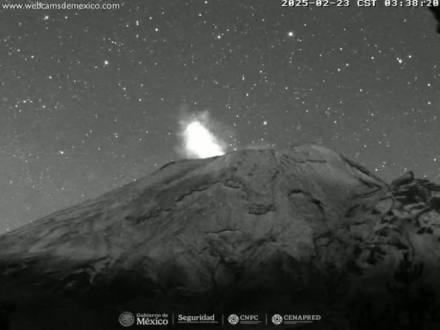 A volcano erupts under a clear, starlit night sky.