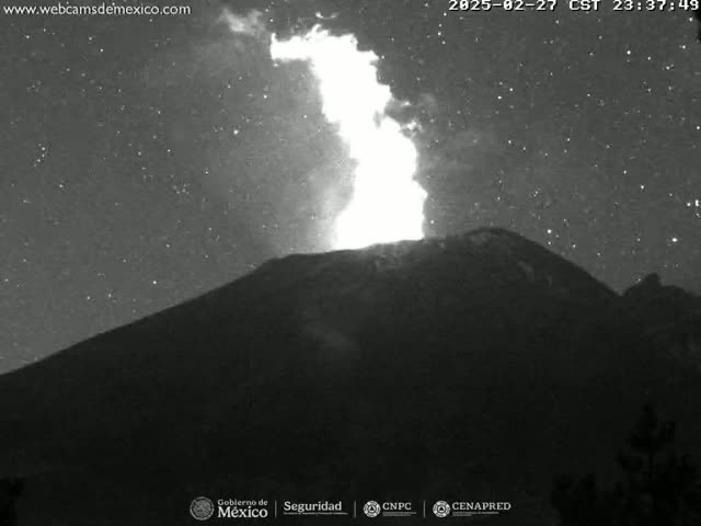 A nighttime, starlit view shows a volcano erupting with a bright plume of fire and smoke.