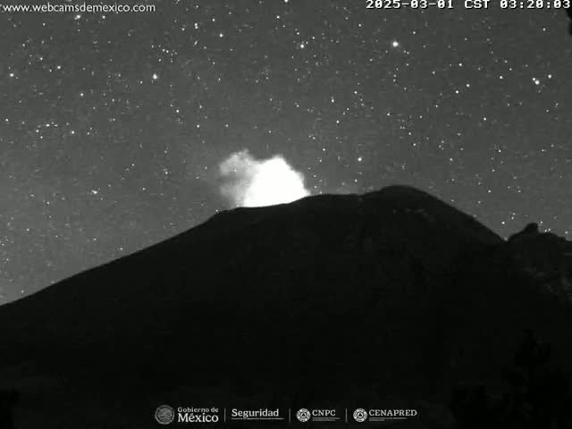 A dark, large volcano erupts a plume of smoke under a clear, starry night sky.