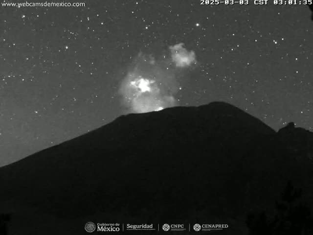 A dark, starlit night reveals a volcano with a faint plume of light emanating from its peak.