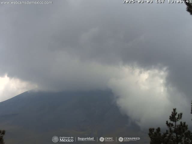 A large, dark mountain is partially obscured by an overcast sky.