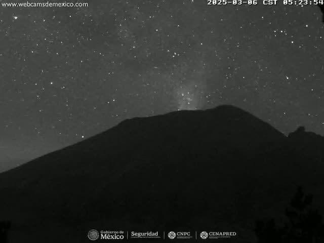 A dark, star-filled night sky is visible above a silhouetted mountain.
