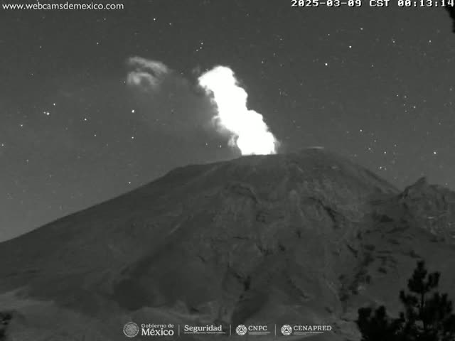 A volcano erupts at night under a clear, starry sky.