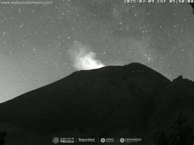 A dark, silhouetted mountain is seen under a starry night sky, with a small plume of smoke or steam emanating from its peak.