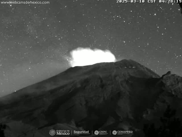 A nighttime, grayscale image shows a volcano erupting under a starry sky.