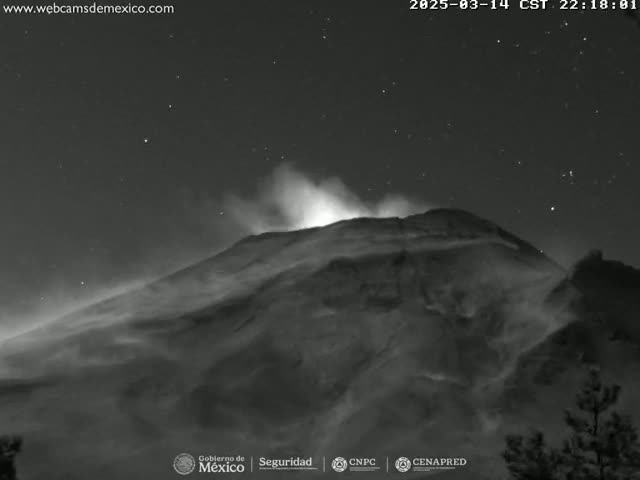 A volcano erupts under a clear, starry night sky.