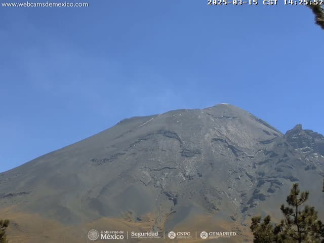 A large, dark gray volcano is visible under a clear blue sky.