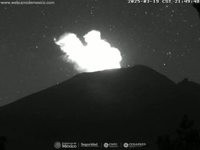A volcano erupts at night under a starry sky, emitting a bright plume of smoke and ash.