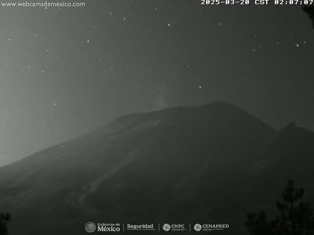 A dark mountain is visible under a clear, starry night sky.