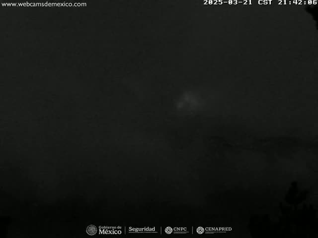 A dark, nighttime scene with a faint, bright area in the distance.