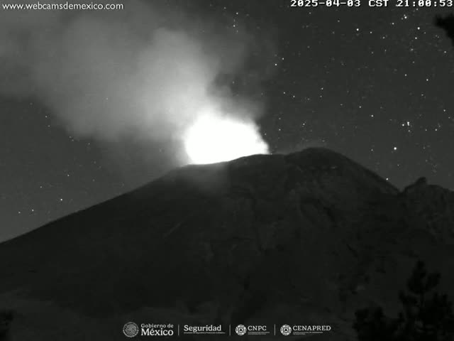 A nighttime, black and white image shows a volcano erupting under a starry sky.