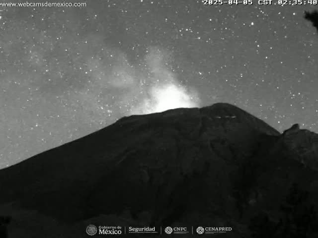A dark, starlit night shows a volcano emitting a plume of smoke under a clear sky.