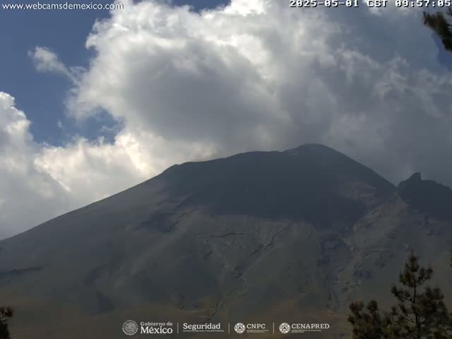 A large, dark-colored mountain is visible under a partly cloudy sky.