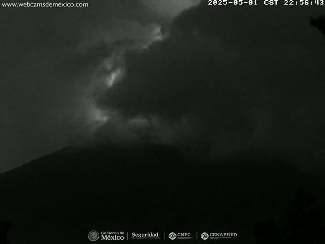 A dark, overcast night sky obscures a mountain shrouded in darkness.