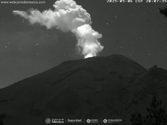 A large plume of smoke erupts from a volcano at night under a starry sky.
