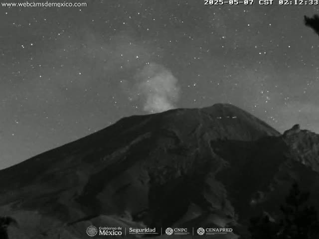 A dark, mountainous volcano emits a plume of smoke under a clear, starry night sky.