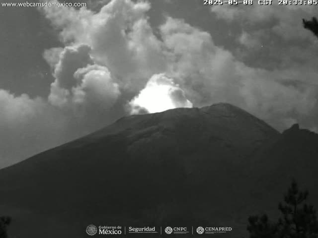 A large, dark mountain is partially obscured by a cloudy, possibly stormy sky.
