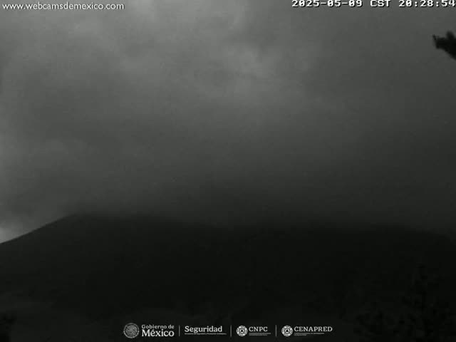 A dark, overcast sky hangs over a silhouetted mountain.
