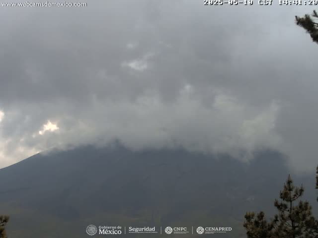 A large, dark mountain is partially obscured by an overcast sky.