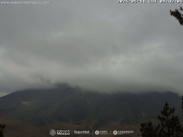 A dark, overcast sky shrouds a large, dark mountain range.