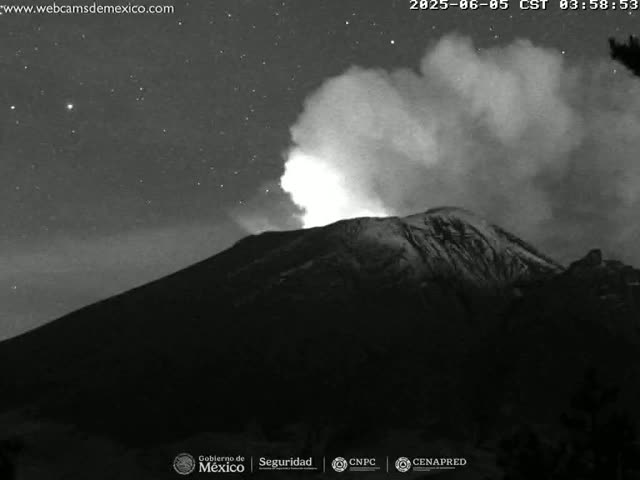 A volcano erupts at night under a starry sky, emitting a plume of smoke and ash.