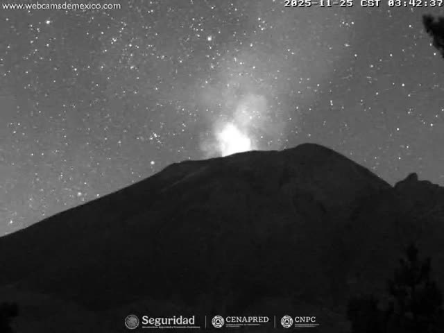 A volcano erupts with a bright plume of smoke or ash against a clear, star-filled night sky.