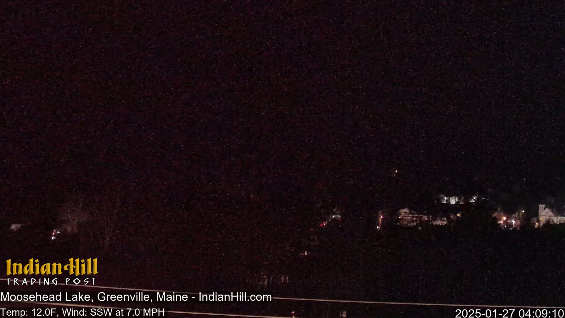 A nighttime long shot shows a dark landscape with a few distant lights under a clear, starlit sky.