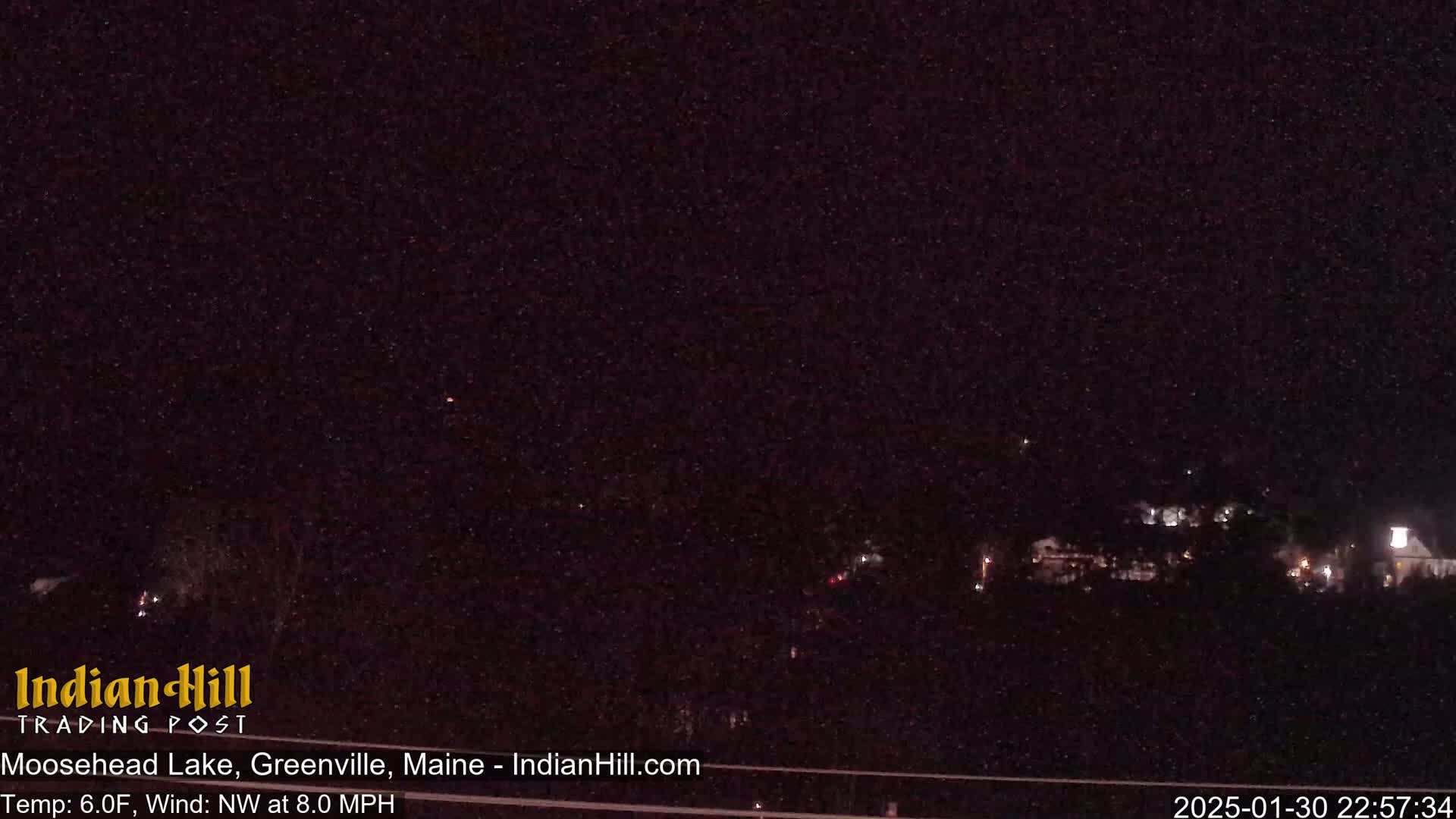 A nighttime, snowy view of a dimly lit town.