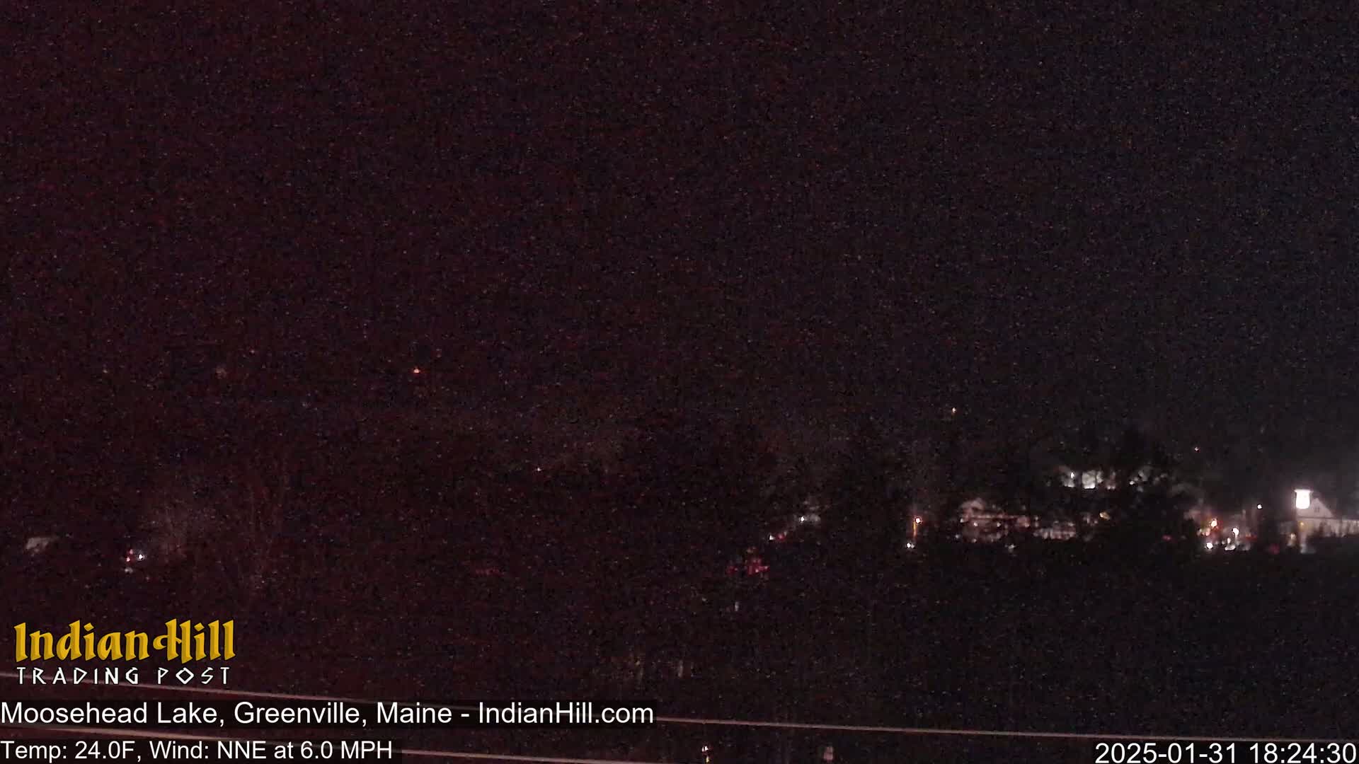 A nighttime long shot shows a dark landscape with a few distant lights under a clear, starlit sky.