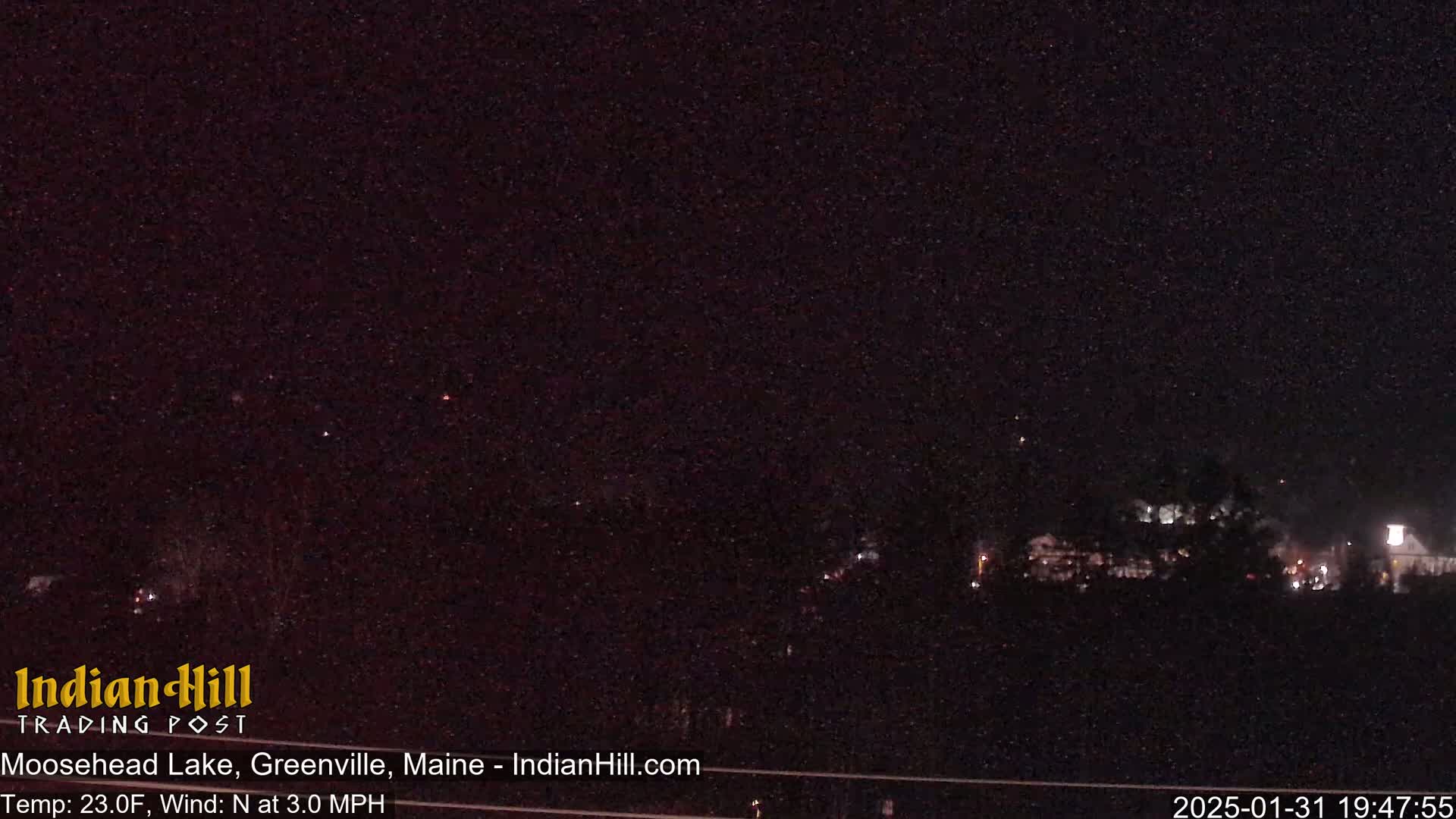 A nighttime long shot of a town under a dark, clear sky with a few visible stars.