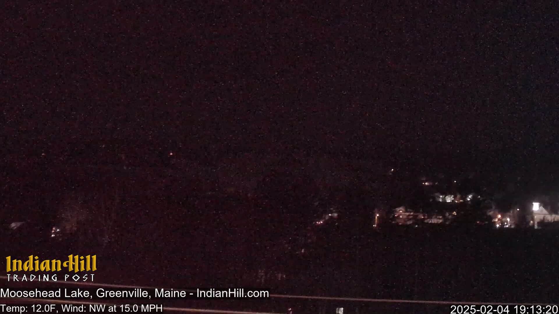 A nighttime long shot of a dark, sparsely lit landscape with a northwest wind at 15 mph and a temperature of 12 degrees Fahrenheit.