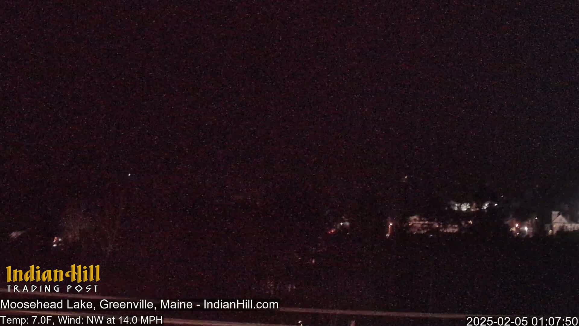 A nighttime, long shot of a dimly lit landscape under a dark, starlit sky with a northwest wind blowing at 14 mph.