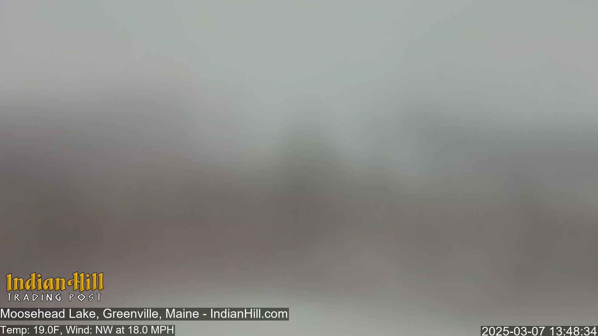A blurry, gray view of an outdoor scene in foggy or hazy conditions.