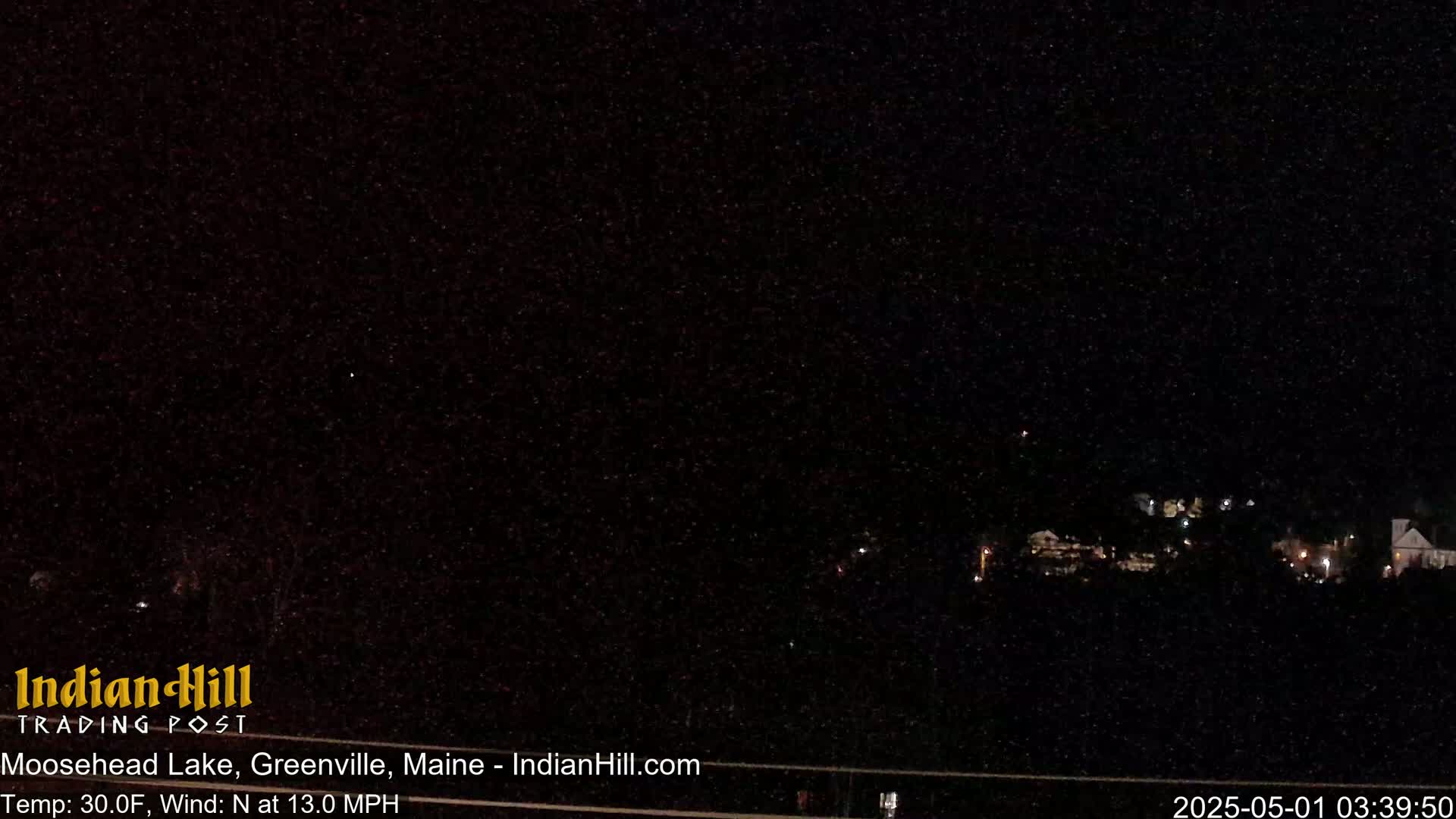 A nighttime view of a dark, sparsely lit landscape with a north wind of 13 mph and a temperature of 30°F.