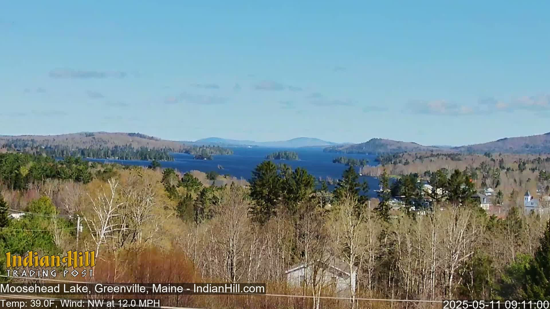 A view of Moosehead Lake from a wooded hillside on a clear, sunny day with a temperature of 39°F and a northwest wind at 12 mph.