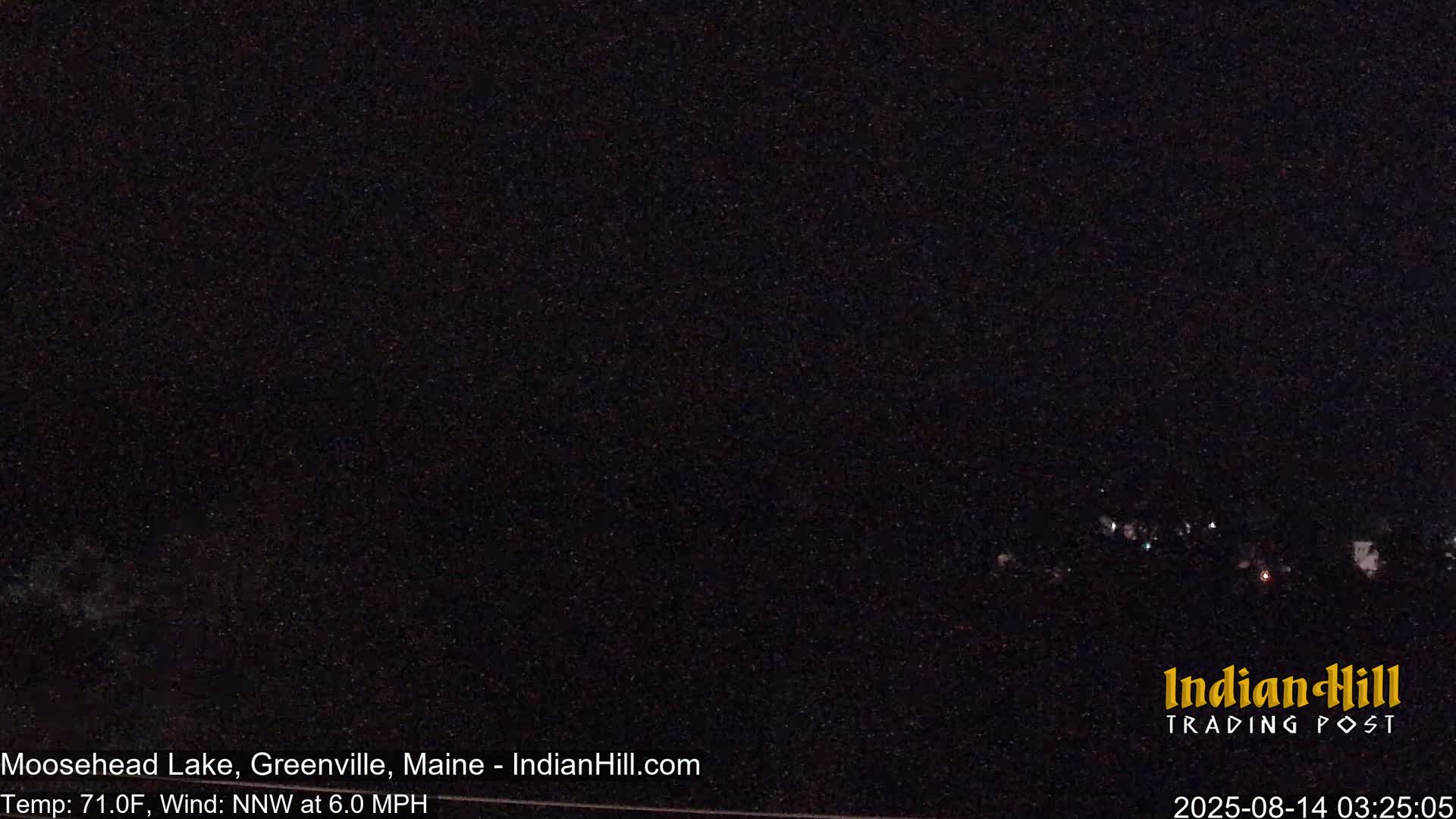 A nighttime long shot shows a dark landscape with a few distant lights under a clear, dark sky.