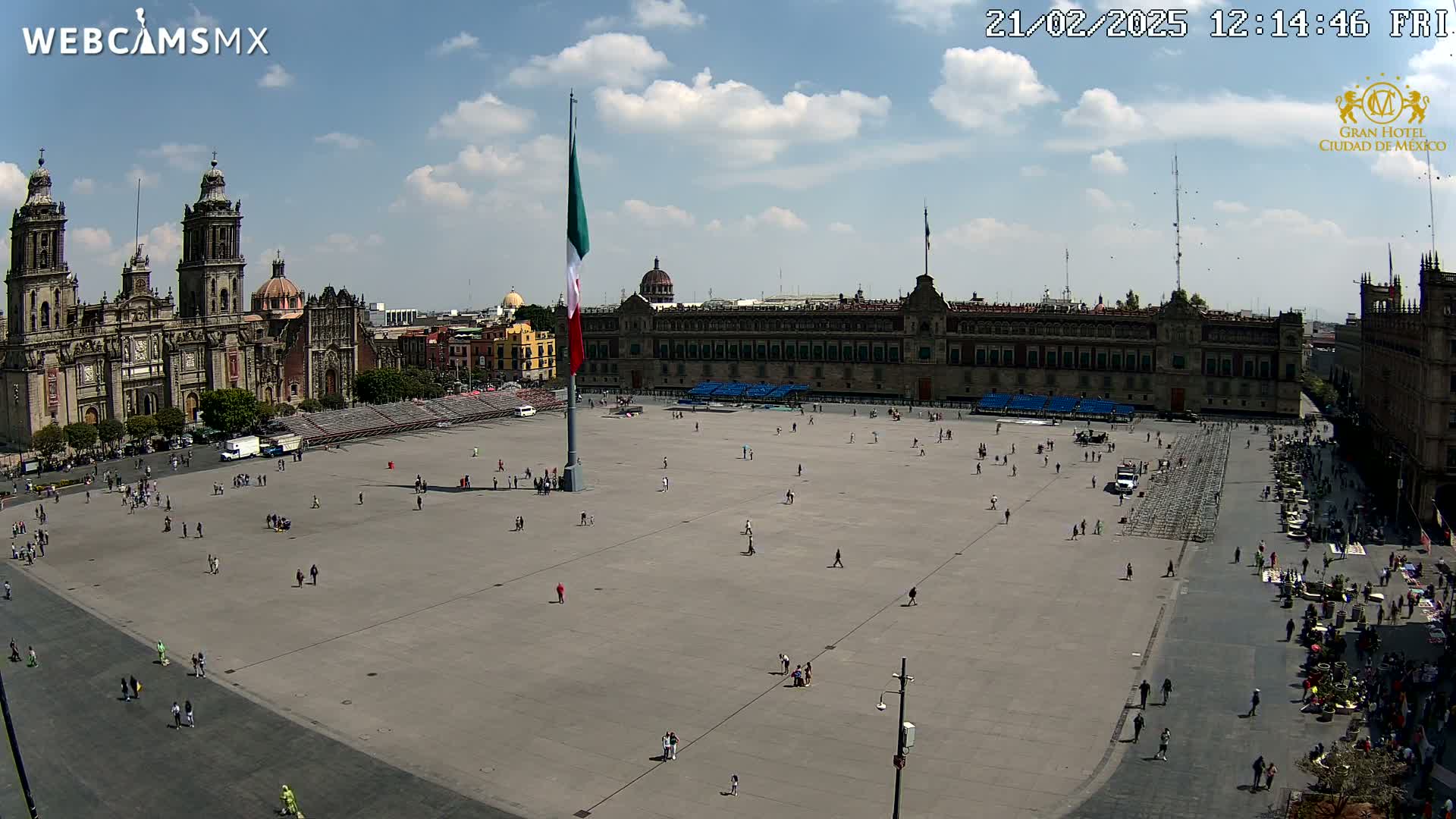 A large plaza with a cathedral and government building on either side, under a partly cloudy sky.