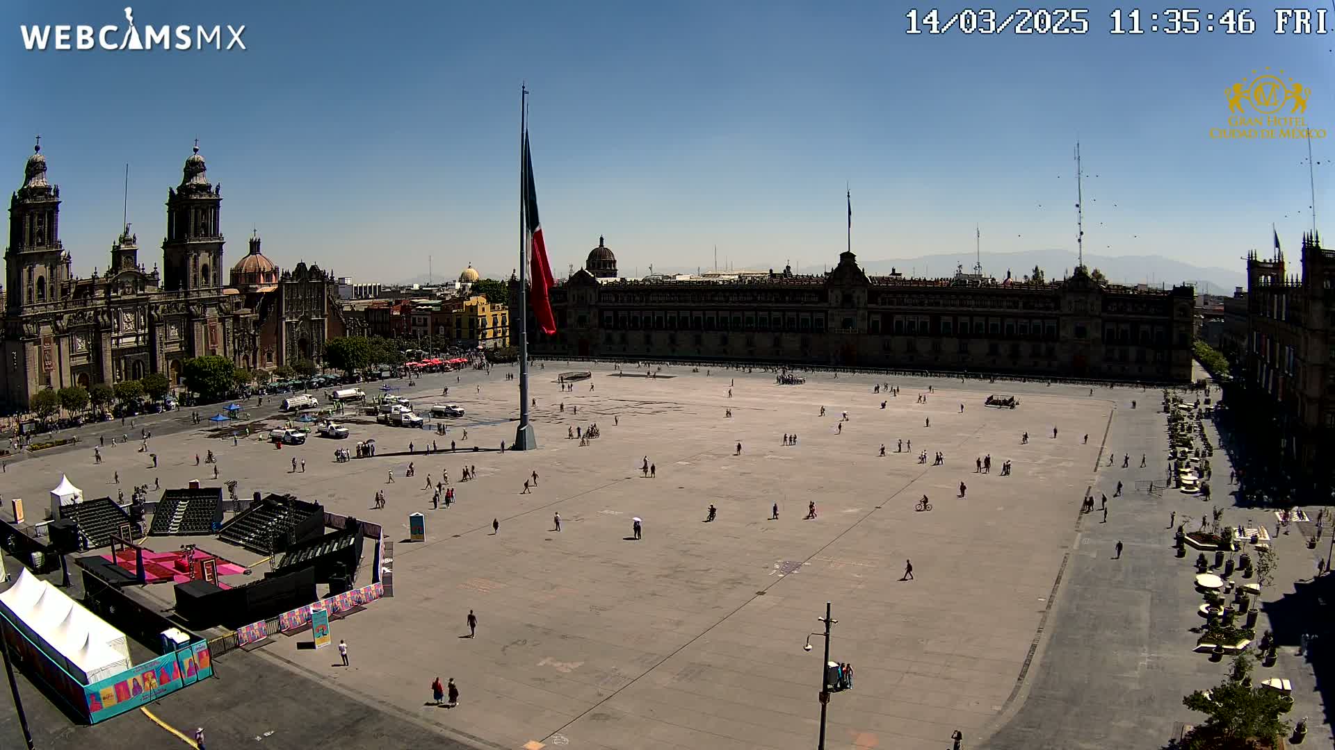 A large plaza with a cathedral and government building on a sunny day, sparsely populated with people.