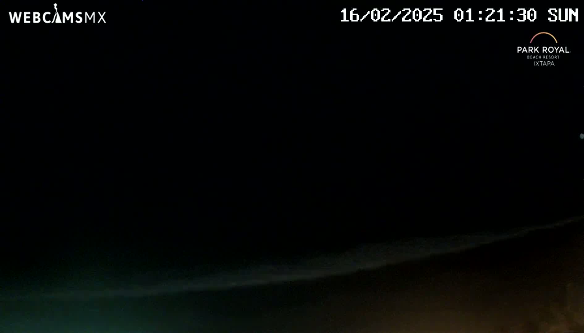 A dark night scene shows a dimly lit ocean horizon under a mostly clear sky.