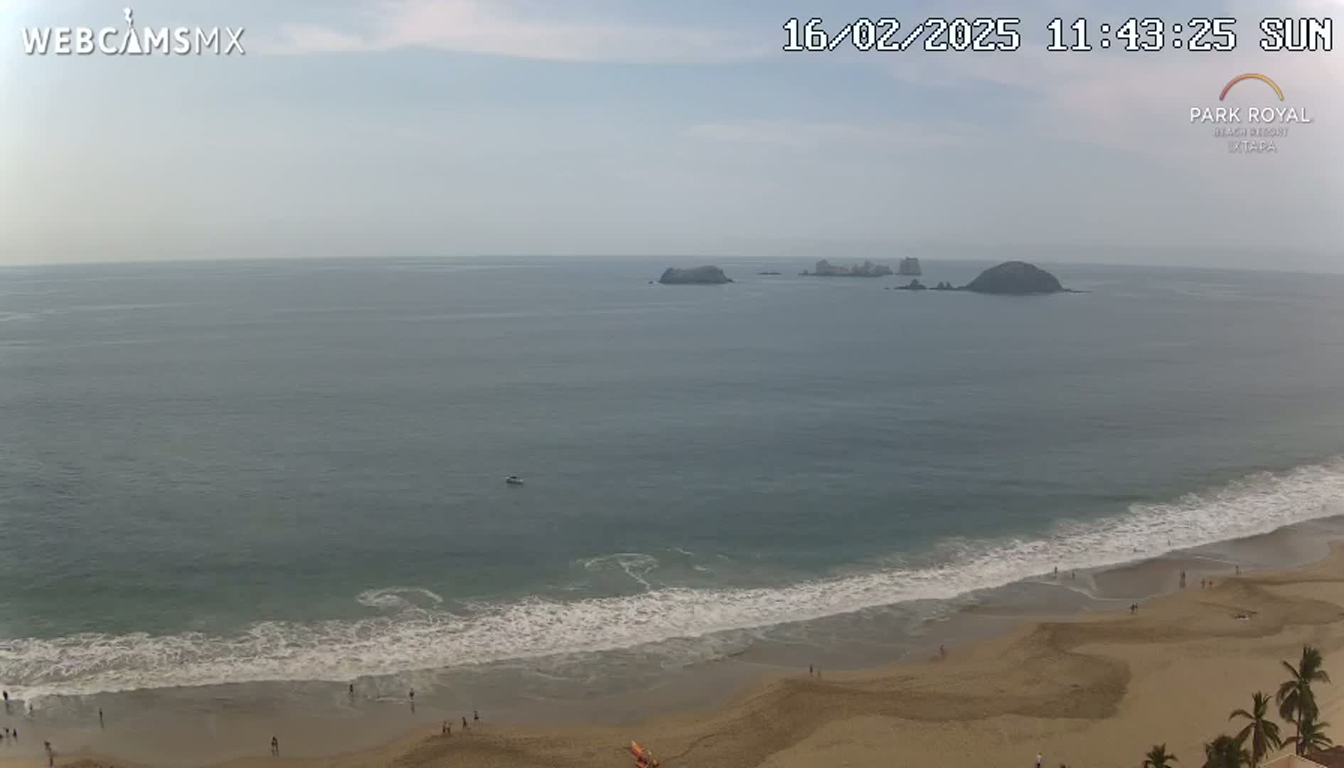 A mostly sunny beach scene shows calm ocean waves lapping a sandy shore with a few people visible, and small islands in the distance.
