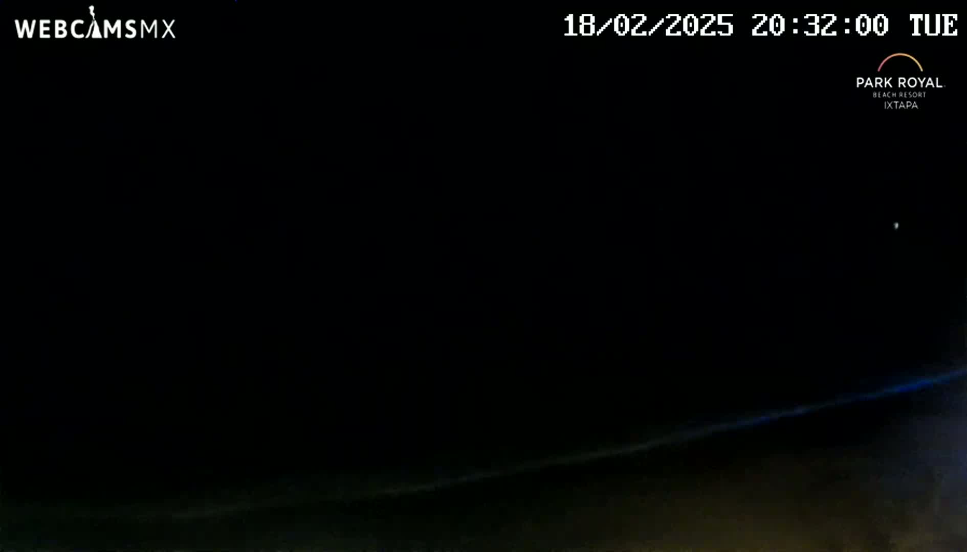 A nighttime, dark outdoor scene shows a faint, horizontal line of light near the bottom edge of the frame.